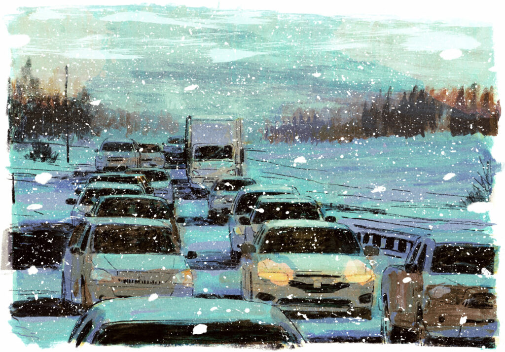 Plusieurs autos sont à l'arrêt, dans le traffic. La neige tombe en gros flocons, la route est emplie de neige.