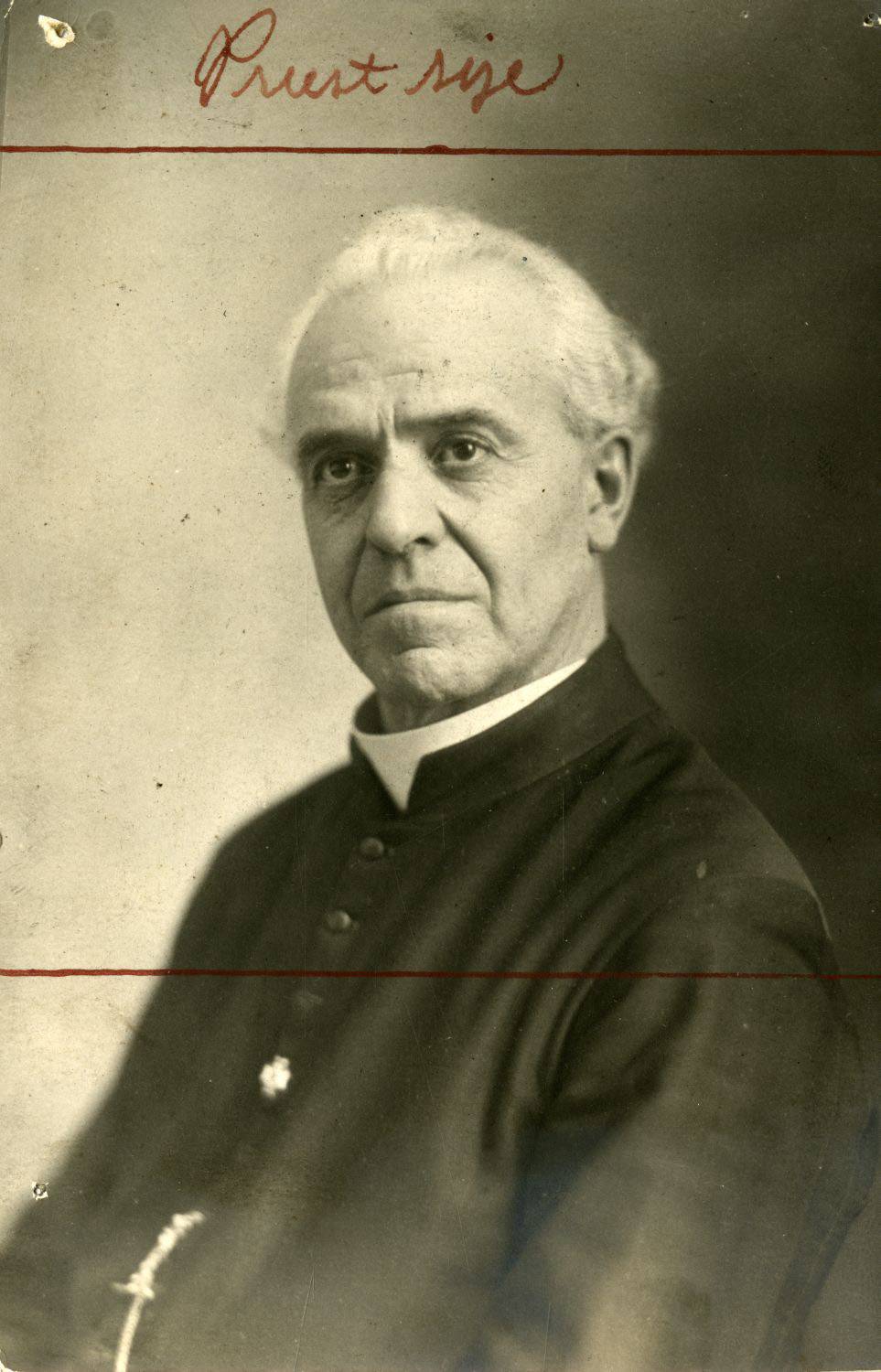 Photographie en noir et blanc, portrait du curé Joseph-Arcade Éthier, curé de la paroisse de Saint-Joseph-d’Ely de Valcourt. La photographie est abîmée et on y voit l’annotation qui semble être Priest size ainsi que deux traits rouges au-dessus de la tête du curé et sous son épaule.